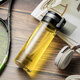 HEENOOR Einschichtglas Tasse für Männer und Frauen großer Kapazität Hebeding Ring Tragbarer Außen und Lecksotzahl hitzebeständiger Tee-Tassen Filter-Teewasser-Tasse Heben tragbar (mit Filter) 695 ml